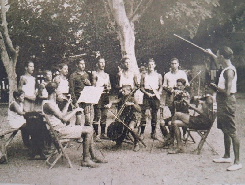 Στιγμιότυπο από το 1929: Η χορωδία και η ορχήστρα της κατασκήνωσης, με τον Ζ. Χαρατσάρη να διευθύνει