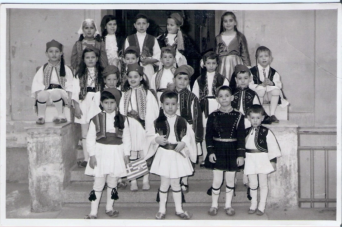 Ως τσολιάς στα σκαλάκια του δημοτικού στη διάρκεια κάποιας σχολικής γιορτής. Είναι στη μέση της δεύτερης από επάνω σειράς, τέταρτος από αριστερά