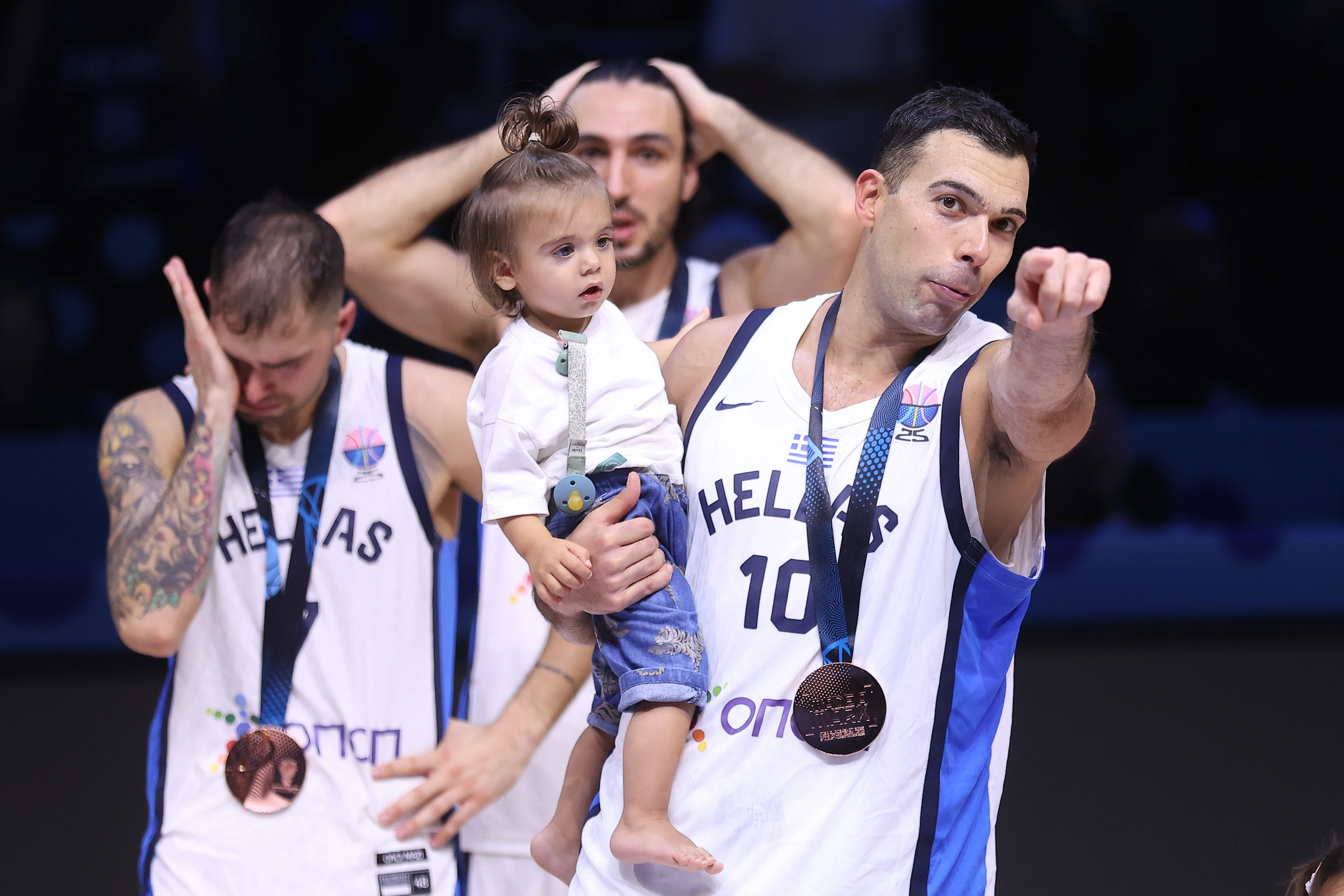 Ο Κώστας Σλούκας αγκαλιά με την κόρη του και στο βάθος Βασίλης Τολιόπουλος και Δημήτρης Κατσίβελης 