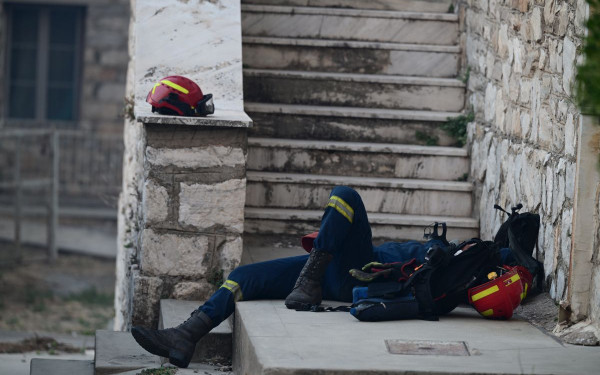Φωτιά στην Αττική: Συγκλονιστική φωτογραφία - Αποκαμωμένος πυροσβέστης ξεκουράζεται σε πεζούλι